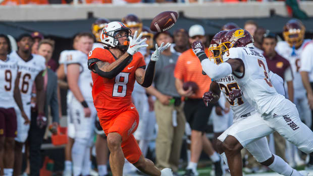 Sep 1, 2022; Stillwater, Oklahoma, USA; Oklahoma State Cowboys wide receiver Braydon Johnson (8) catches the ball over Central Michigan Chippewas defensive back Trey Jones (3) and defensive back Rolliann Sturkey (37) during the first quarter at Boone Pickens Stadium. Oklahoma State won 58-44.