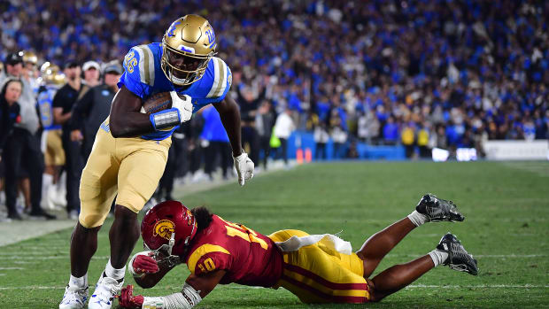 Nov 19, 2022; Pasadena, California, USA; UCLA Bruins tight end Michael Ezeike (86) runs the ball for a touchdown against Southern California Trojans linebacker Ralen Goforth (10) during the second half at the Rose Bowl.