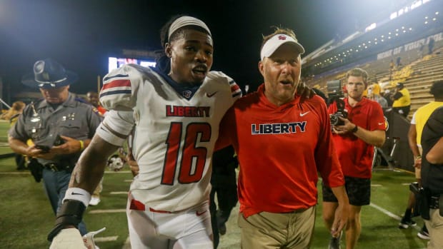 Sep 3, 2022; Hattiesburg, Mississippi, USA; Liberty Flames safety Quinton Reese (16) walks off the field with Liberty Flames head coach Hugh Freeze after win over the Southern Miss Golden Eagles at M.M. Roberts Stadium. Liberty won in overtime, 29-27.