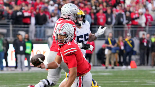 Nov 26, 2022; Columbus, OH, USA; Ohio State Buckeyes quarterback C.J. Stroud (7) throws an interception while Michigan Wolverines defensive lineman Rayshaun Benny (26) tries to tackle him late in the fourth quarter of their game at Ohio Stadium.