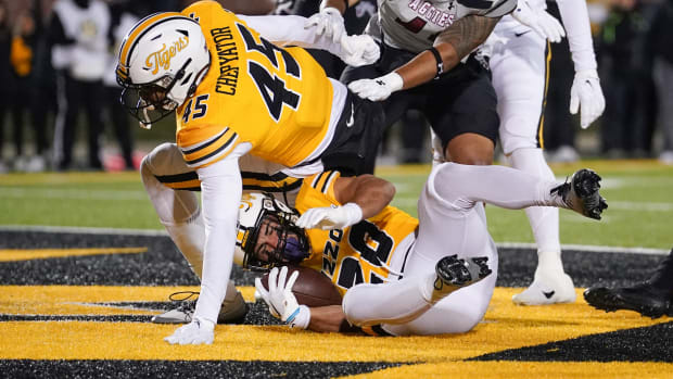 Nov 19, 2022; Columbia, Missouri, USA; Missouri Tigers running back Cody Schrader (20) scores a touchdown against New Mexico State Aggies linebacker Buddha Peleti (40) during the first half at Faurot Field at Memorial Stadium.