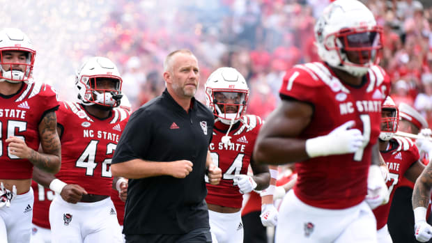 Sep 10, 2022; Raleigh, North Carolina, USA; North Carolina State Wolfpack head coach Dave Doeren (center) leads his team onto the field prior to a game against the Charleston Southern Buccaneers at Carter-Finley Stadium.