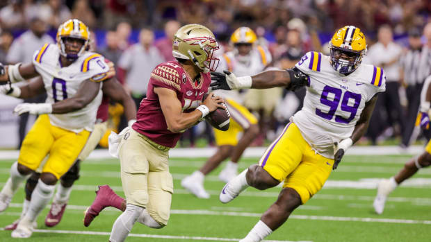 Sep 4, 2022; New Orleans, Louisiana, USA; Florida State Seminoles quarterback Jordan Travis (13) scrambles out the pocket against LSU Tigers defensive tackle Jaquelin Roy (99) during the first half of the game at Caesars Superdome.