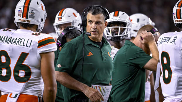 Sep 17, 2022; College Station, Texas, USA; Miami Hurricanes head coach Mario Cristobal talks with this team during a timeout during the second half of the game between the Texas A&M Aggies and the Miami Hurricanes at Kyle Field.