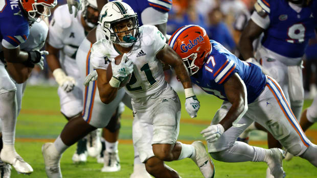 Sep 17, 2022; Gainesville, Florida, USA; South Florida Bulls running back Brian Battie (21) runs with the ball as Florida Gators linebacker Scooby Williams (17) tackles during the second half at Ben Hill Griffin Stadium.
