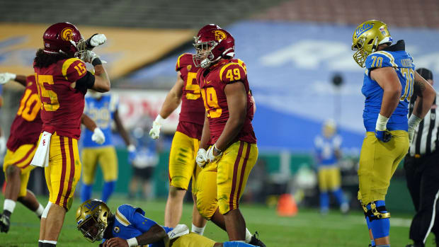 Dec 12, 2020; Pasadena, California, USA; Southern California Trojans safety Talanoa Hufanga (15) and defensive lineman Tuli Tuipulotu (49) celebrate after a sack of UCLA Bruins quarterback Dorian Thompson-Robinson (1) as offensive lineman Alec Anderson (70) watches in the third quarterat Rose Bowl. USC defeated UCLA 43-38.