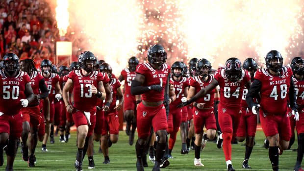 Sep 24, 2022; Raleigh, North Carolina, USA; North Carolina State Wolfpack linebacker Isaiah Moore (1) and quarterback Devin Leary (13) lead their team onto the field prior to a game against the Connecticut Huskies at Carter-Finley Stadium.