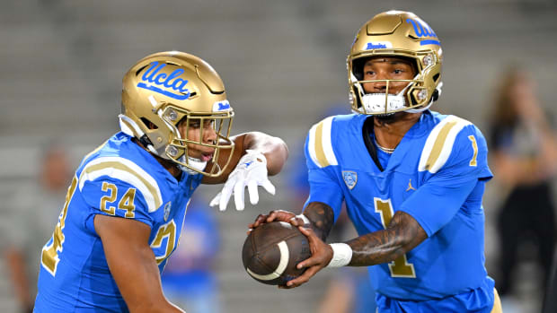 Sep 30, 2022; Pasadena, California, USA; UCLA Bruins quarterback Dorian Thompson-Robinson (1) hands off to running back Zach Charbonnet (24) as they warm up prior to the game against the Washington Huskies at the Rose Bowl.