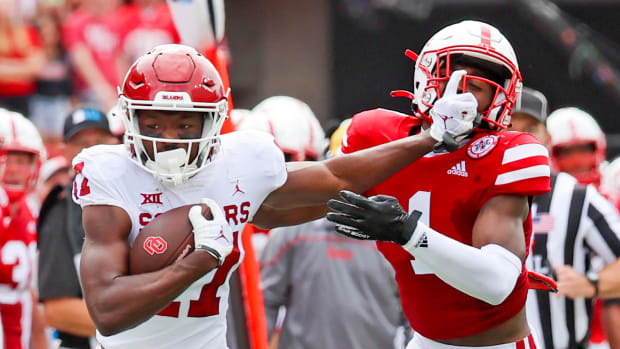 Sep 17, 2022; Lincoln, Nebraska, USA; Oklahoma Sooners wide receiver Marvin Mims (17) stiff arms Nebraska Cornhuskers defensive back Marques Buford Jr. (1) during the first half at Memorial Stadium.
