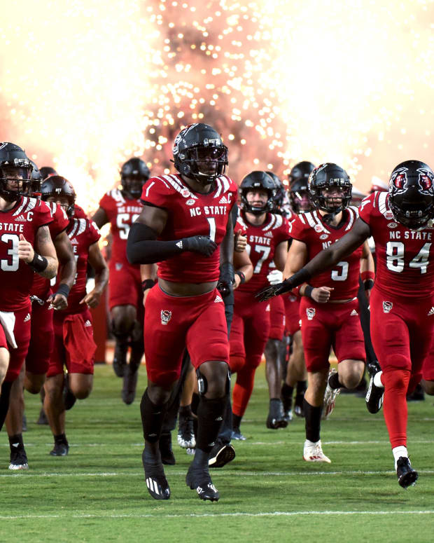 Sep 24, 2022; Raleigh, North Carolina, USA; North Carolina State Wolfpack linebacker Isaiah Moore (1) and quarterback Devin Leary (13) lead their team onto the field prior to a game against the Connecticut Huskies at Carter-Finley Stadium.