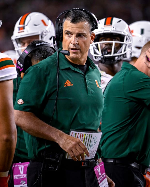 Sep 17, 2022; College Station, Texas, USA; Miami Hurricanes head coach Mario Cristobal talks with this team during a timeout during the second half of the game between the Texas A&M Aggies and the Miami Hurricanes at Kyle Field.