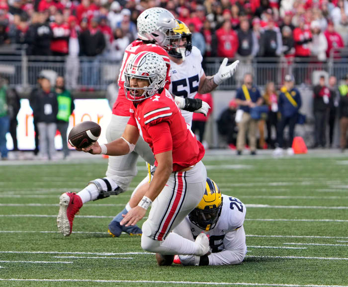 Nov 26, 2022; Columbus, OH, USA; Ohio State Buckeyes quarterback C.J. Stroud (7) throws an interception while Michigan Wolverines defensive lineman Rayshaun Benny (26) tries to tackle him late in the fourth quarter of their game at Ohio Stadium.