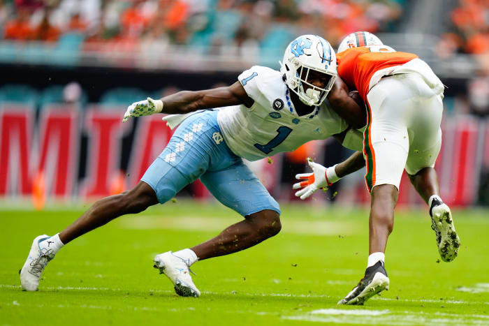 Oct 8, 2022; Miami Gardens, Florida, USA; North Carolina Tar Heels defensive back Tony Grimes (1) tackles Miami Hurricanes wide receiver Frank Ladson Jr. (8) during the first half at Hard Rock Stadium.