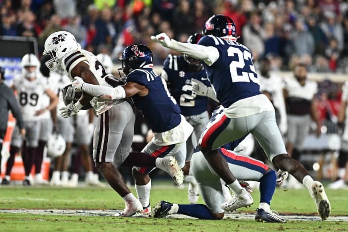 Nov 24, 2022; Oxford, Mississippi, USA;Mississippi State Bulldogs running back Dillon Johnson (23) runs the ball while defended by Ole Miss Rebels linebacker Troy Brown (8) during the second quarter at Vaught-Hemingway Stadium.