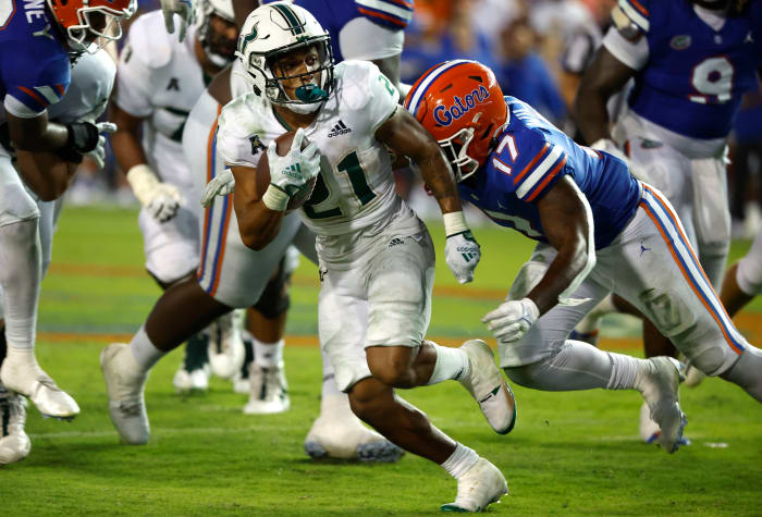 Sep 17, 2022; Gainesville, Florida, USA; South Florida Bulls running back Brian Battie (21) runs with the ball as Florida Gators linebacker Scooby Williams (17) tackles during the second half at Ben Hill Griffin Stadium.
