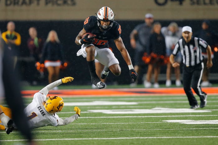 Sep 10, 2022; Stillwater, Oklahoma, USA; Oklahoma State Cowboys running back Dominic Richardson (20) leaps over Arizona State Sun Devils defensive back Jordan Clark (1) during a game at Boone Pickens Stadium. Oklahoma State won 34-17.