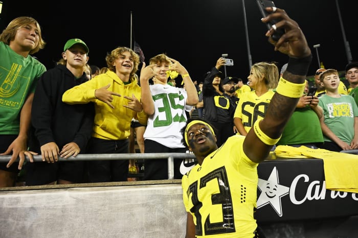 Sep 10, 2022; Eugene, Oregon, USA; Oregon Ducks linebacker Jeffrey Bassa (33) takes a selfie with young Ducks fans after a game against Eastern Washington Eagles at Autzen Stadium. The Ducks won 70-14.