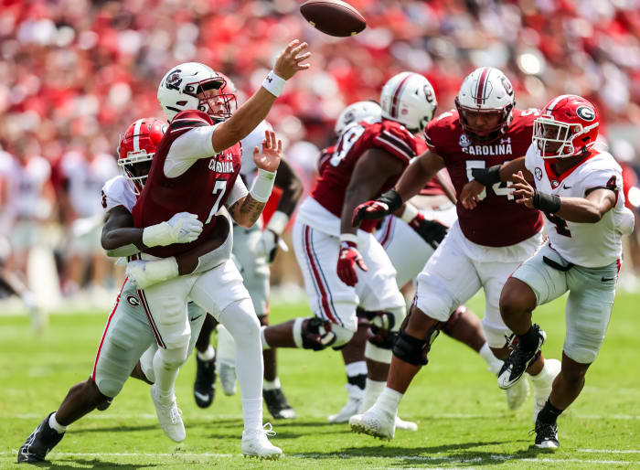 Sep 17, 2022; Columbia, South Carolina, USA; South Carolina Gamecocks quarterback Spencer Rattler (7) passes as he is hit by Georgia Bulldogs defensive lineman Mykel Williams (13) in the second quarter at Williams-Brice Stadium.