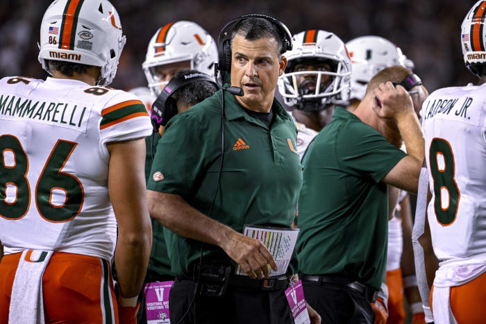 Sep 17, 2022; College Station, Texas, USA; Miami Hurricanes head coach Mario Cristobal talks with this team during a timeout during the second half of the game between the Texas A&M Aggies and the Miami Hurricanes at Kyle Field.