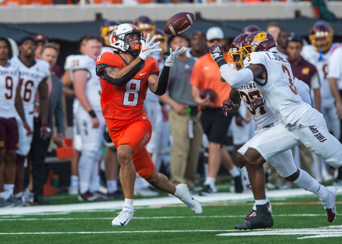 Sep 1, 2022; Stillwater, Oklahoma, USA; Oklahoma State Cowboys wide receiver Braydon Johnson (8) catches the ball over Central Michigan Chippewas defensive back Trey Jones (3) and defensive back Rolliann Sturkey (37) during the first quarter at Boone Pickens Stadium. Oklahoma State won 58-44.