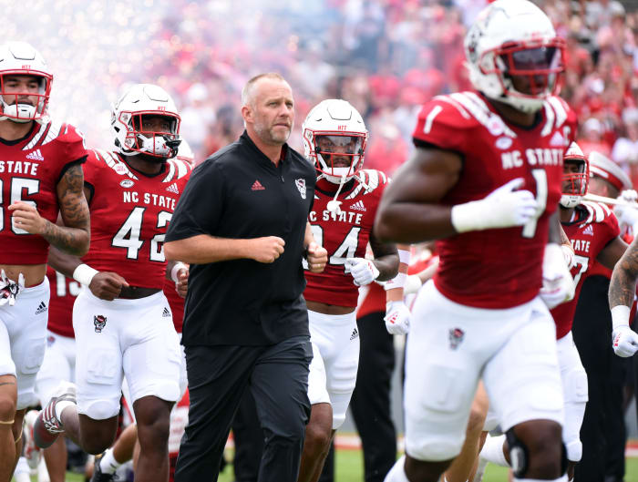 Sep 10, 2022; Raleigh, North Carolina, USA; North Carolina State Wolfpack head coach Dave Doeren (center) leads his team onto the field prior to a game against the Charleston Southern Buccaneers at Carter-Finley Stadium.