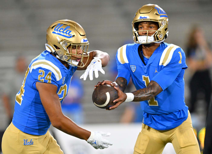 Sep 30, 2022; Pasadena, California, USA; UCLA Bruins quarterback Dorian Thompson-Robinson (1) hands off to running back Zach Charbonnet (24) as they warm up prior to the game against the Washington Huskies at the Rose Bowl.