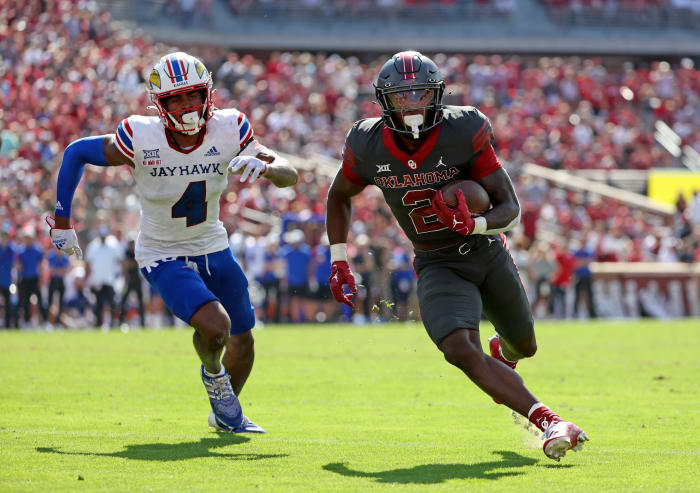 Oct 15, 2022; Norman, Oklahoma, USA; Oklahoma Sooners running back Jovantae Barnes (2) runs with the ball as Kansas Jayhawks safety Marvin Grant (4) defends during the game at Gaylord Family-Oklahoma Memorial Stadium.