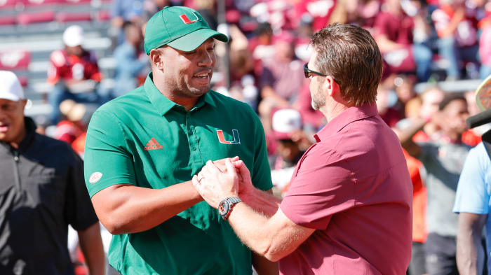 Oct 15, 2022; Blacksburg, Virginia, USA; Miami Hurricanes offensive coordinator Josh Gattis (left) greets Virginia Tech Hokies head coach Brent Pry before the game at Lane Stadium.