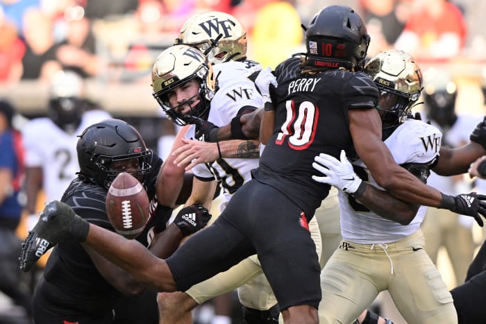 Oct 29, 2022; Louisville, Kentucky, USA; Wake Forest Demon Deacons quarterback Sam Hartman (10) fumbles the ball against Louisville Cardinals defensive lineman Jared Dawson (93) during the second half at Cardinal Stadium. Louisville won 48-21.