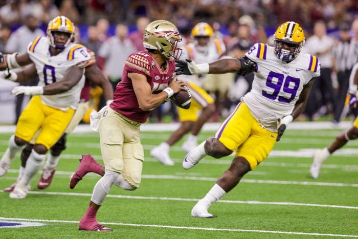 Sep 4, 2022; New Orleans, Louisiana, USA; Florida State Seminoles quarterback Jordan Travis (13) scrambles out the pocket against LSU Tigers defensive tackle Jaquelin Roy (99) during the first half of the game at Caesars Superdome.