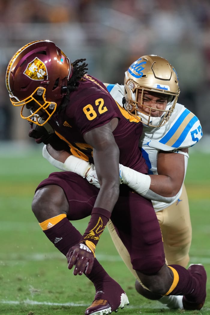 Nov 5, 2022; Tempe, Arizona, USA; UCLA Bruins linebacker Darius Muasau (53) tackles Arizona State Sun Devils wide receiver Andre Johnson (82) during the first half at Sun Devil Stadium.