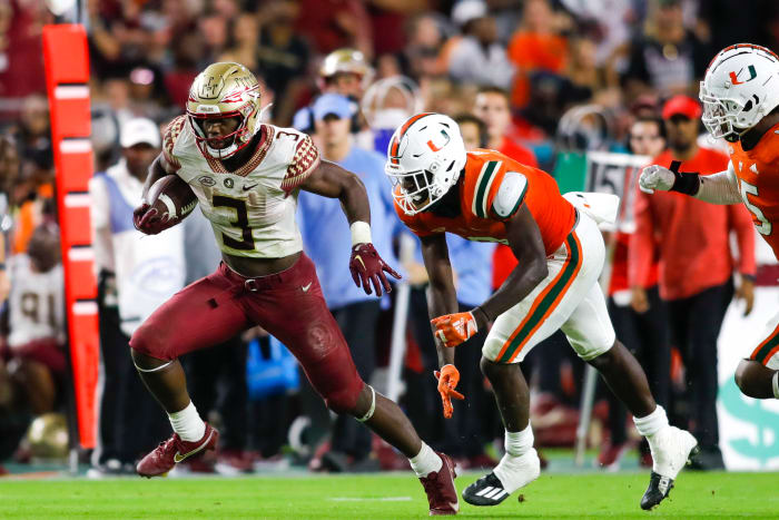 Nov 5, 2022; Miami Gardens, Florida, USA; Florida State Seminoles running back Trey Benson (3) runs with the football ahead of Miami Hurricanes safety James Williams (0) during the third quarter at Hard Rock Stadium.