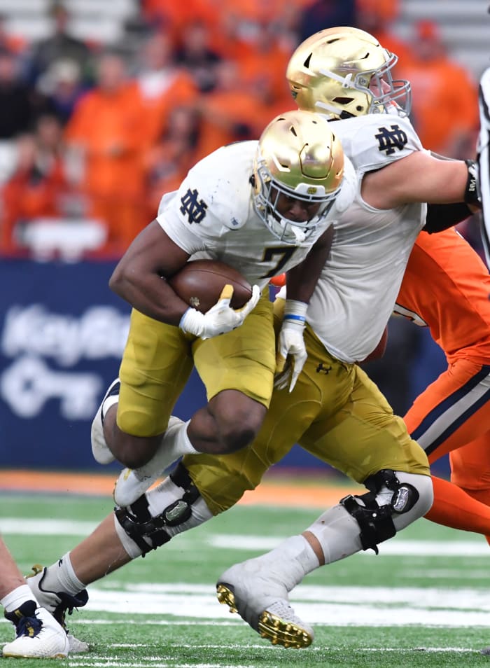 Oct 29, 2022; Syracuse, New York, USA; Notre Dame Fighting Irish running back Audric Estime (7) leaps over the leg of offensive lineman Joe Alt (76) in the fourth quarter game against the Syracuse Orange at JMA Wireless Dome.