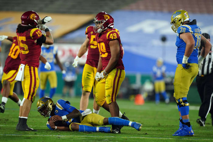 Dec 12, 2020; Pasadena, California, USA; Southern California Trojans safety Talanoa Hufanga (15) and defensive lineman Tuli Tuipulotu (49) celebrate after a sack of UCLA Bruins quarterback Dorian Thompson-Robinson (1) as offensive lineman Alec Anderson (70) watches in the third quarterat Rose Bowl. USC defeated UCLA 43-38.