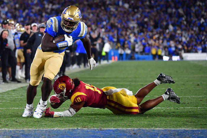Nov 19, 2022; Pasadena, California, USA; UCLA Bruins tight end Michael Ezeike (86) runs the ball for a touchdown against Southern California Trojans linebacker Ralen Goforth (10) during the second half at the Rose Bowl.