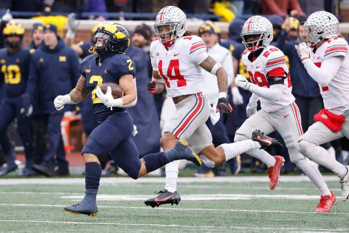 Nov 27, 2021; Ann Arbor, Michigan, USA; Michigan Wolverines running back Blake Corum (2) rushes chased by Ohio State Buckeyes safety Ronnie Hickman (14) and ornerback Denzel Burke (29) at Michigan Stadium.