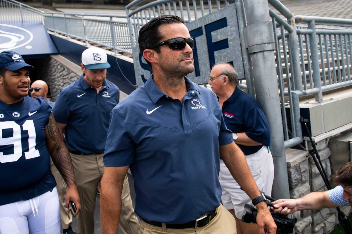 First-year Penn State football defensive coordinator Manny Diaz walks onto the turf with other members of the team during football media day at Beaver Stadium on Saturday, August 6, 2022, in State College.
