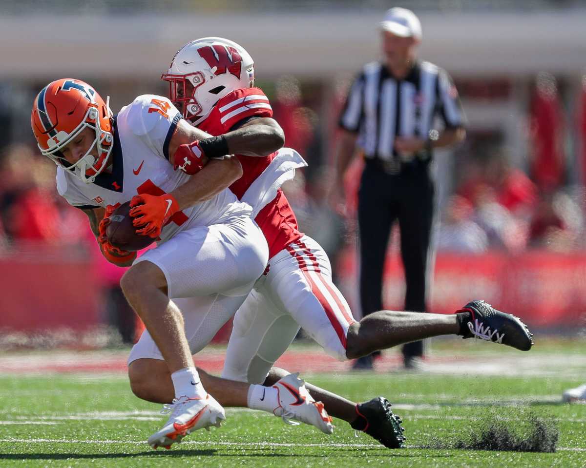 Illinois wide receiver Casey Washington (14) is tackled by Wisconsin cornerback Ricardo Hallman (2) on Saturday, October 1, 2022, at Camp Randall Stadium in Madison, Wis. Illinois won the game, 34-10, in current Illini and former Badgers head coach Bret Bielema s return to Madison.