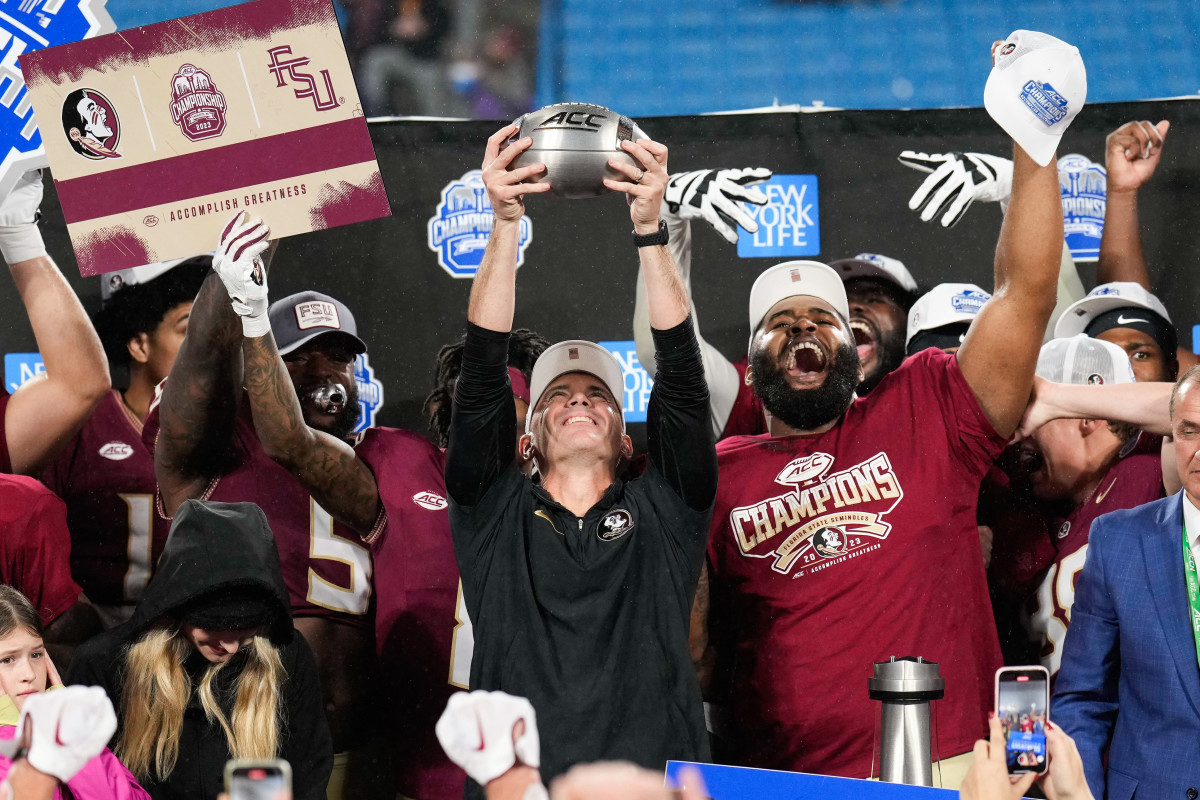 Dec 2, 2023; Charlotte, NC, USA; Florida State Seminoles head coach Mike Norvell raises the ACC Championship trophy with his players after the game against the Louisville Cardinals at Bank of America Stadium. Mandatory Credit: Jim Dedmon-Imagn Images © Jim Dedmon-Imagn Images 