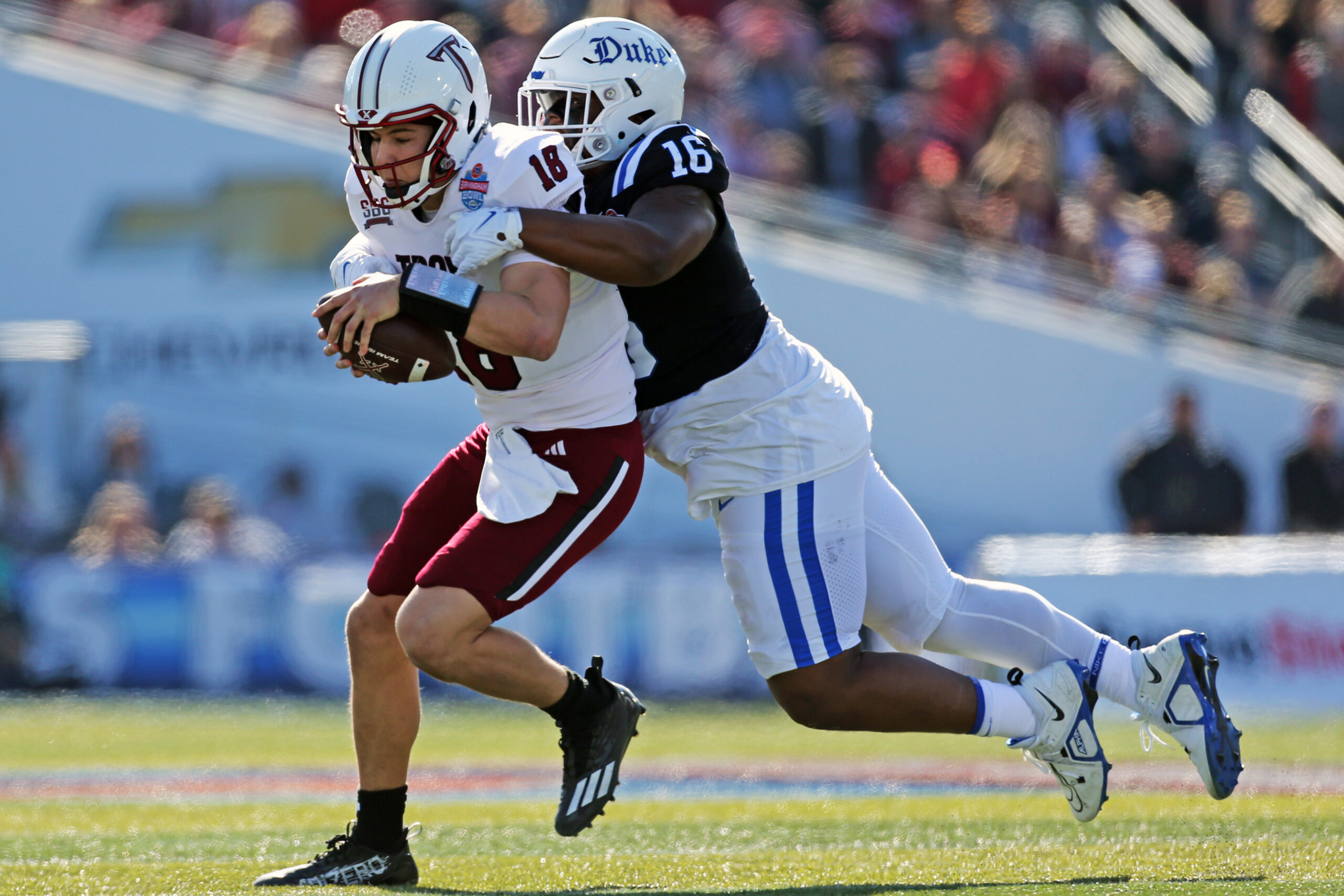 Dec 23, 2023; Birmingham, AL, USA; Duke Blue Devils defensive linemen Aeneas Peebles (16) sacks Troy Trojans quarterback Gunnar Watson (18) during the first half at Protective Stadium. 