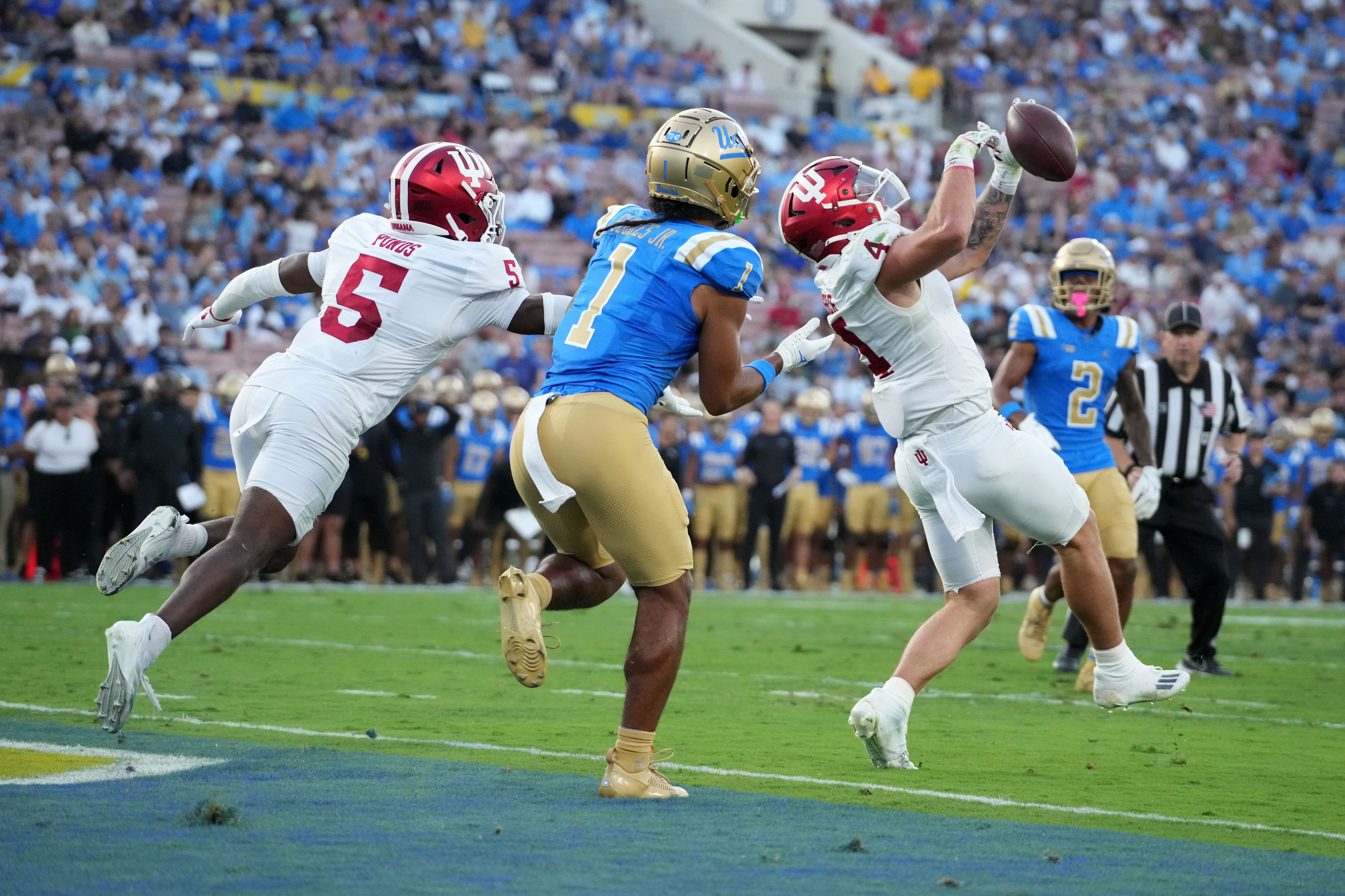 Sep 14, 2024; Pasadena, California, USA; Indiana Hoosiers linebacker Aiden Fisher (4) and defensive back D'Angelo Ponds (5) defend against UCLA Bruins wide receiver Rico Flores Jr. (1) in the first half at Rose Bowl. 