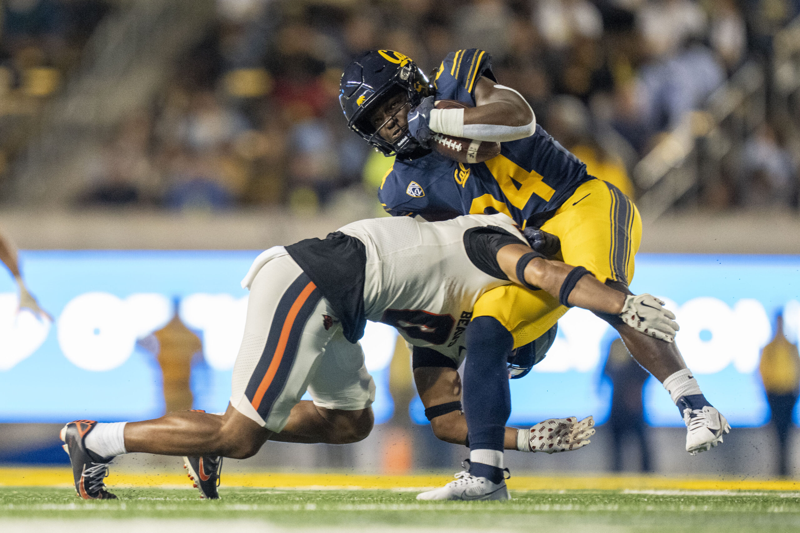 October 7, 2023; Berkeley, California, USA; California Golden Bears running back Ashton Stredick (24) is tackled by Oregon State Beavers defensive back Akili Arnold (0) during the third quarter at California Memorial Stadium.
