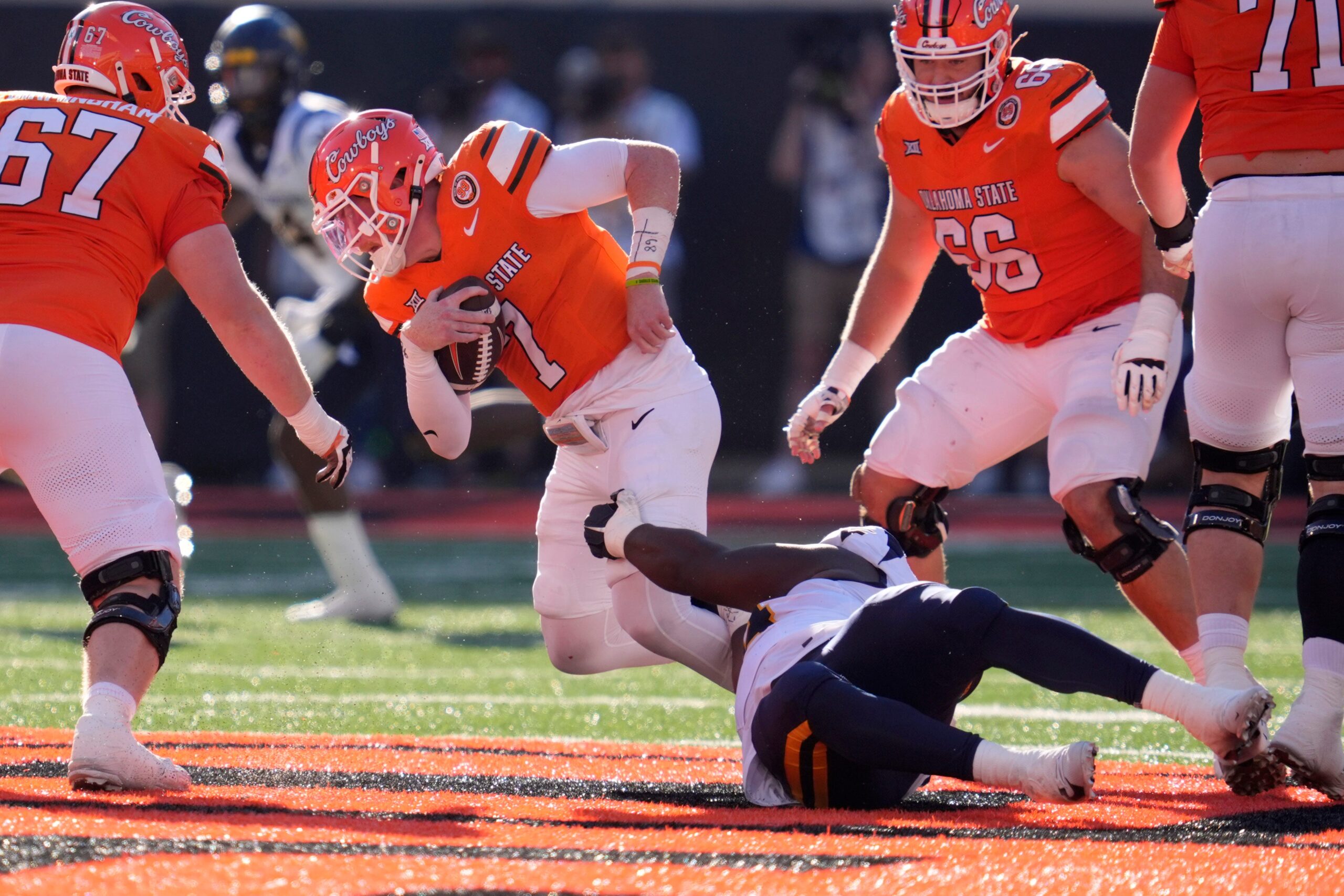 West Virginia Mountaineers defensive lineman Fatorma Mulbah (54) brings down Oklahoma State Cowboys quarterback Alan Bowman (7) during a college football game between the Oklahoma State Cowboys (OSU) and the West Virginia Mountaineers at Boone Pickens Stadium in Stillwater, Okla., Saturday, Oct. 5, 2024.