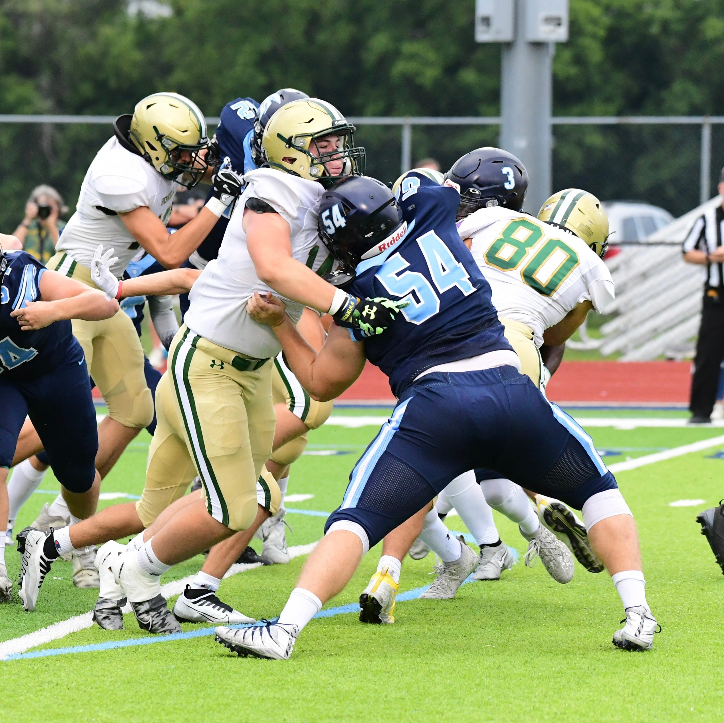 Howell's Bobby Kanka (left) and Livonia Stevenson's Charlie Davidek battle during a football game on Thursday, Aug. 25, 2022.