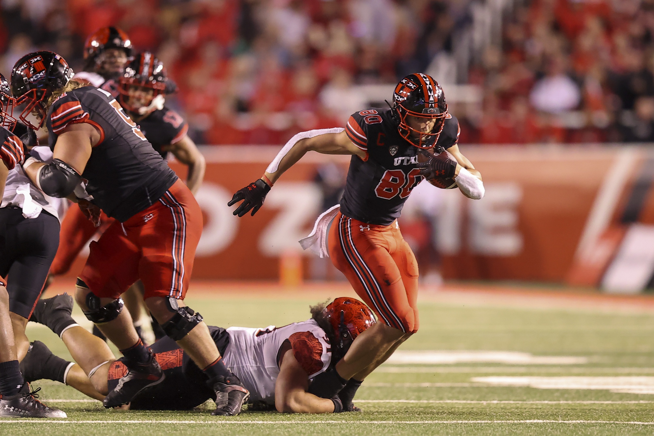 Sep 17, 2022; Salt Lake City, Utah, USA; Utah Utes tight end Brant Kuithe (80) catches a pass and is brought down by San Diego State Aztecs defensive lineman Justus Tavai (91) in the second quarter at Rice-Eccles Stadium.