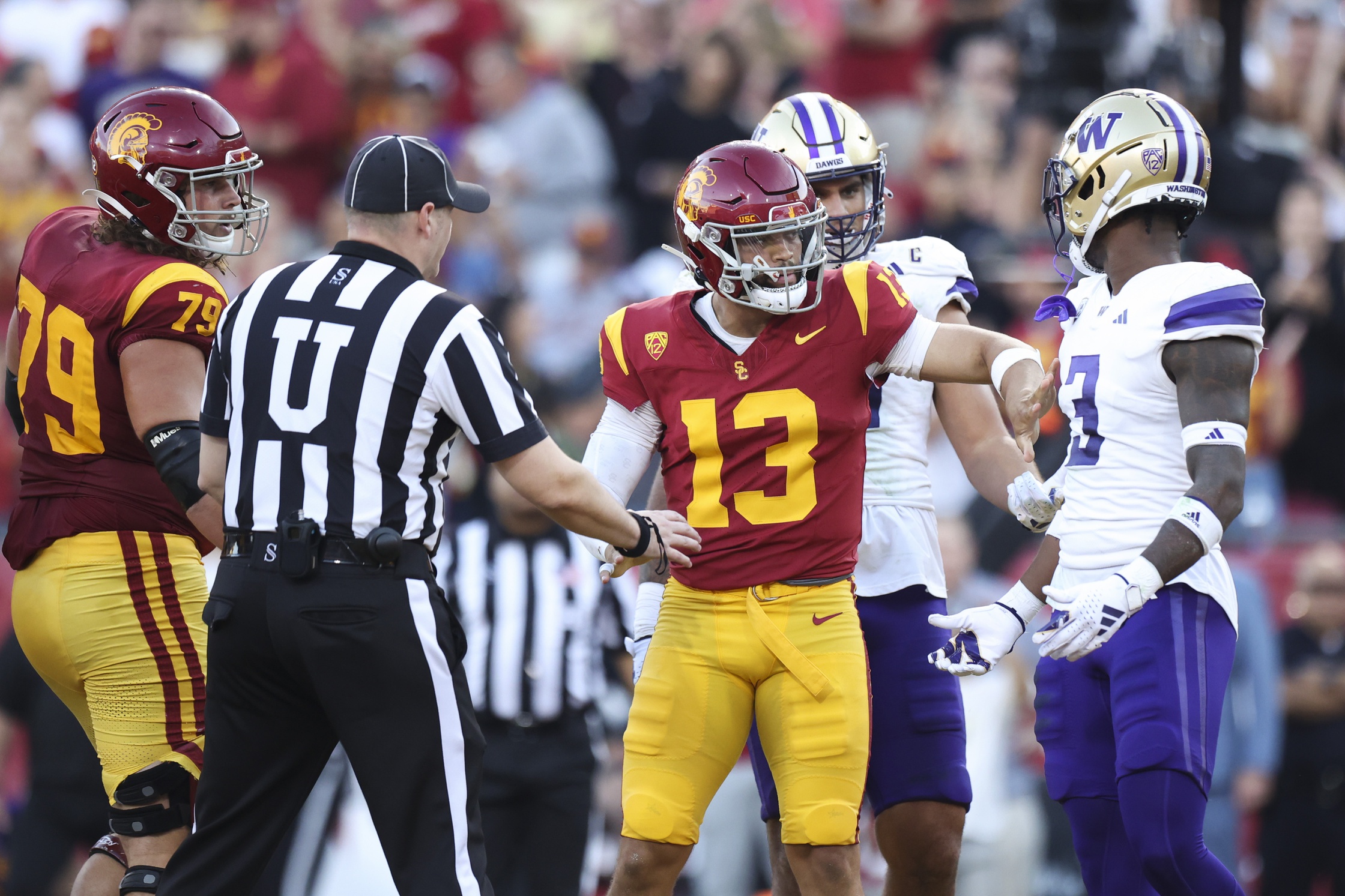 Nov 4, 2023; Los Angeles, California, USA; USC Trojans quarterback Caleb Williams (13) interacts with Washington Huskies safety Mishael Powell (3) after Caleb Williams (13) scores a touchdown during the first quarter against the Washington Huskies at United Airlines Field at Los Angeles Memorial Coliseum.