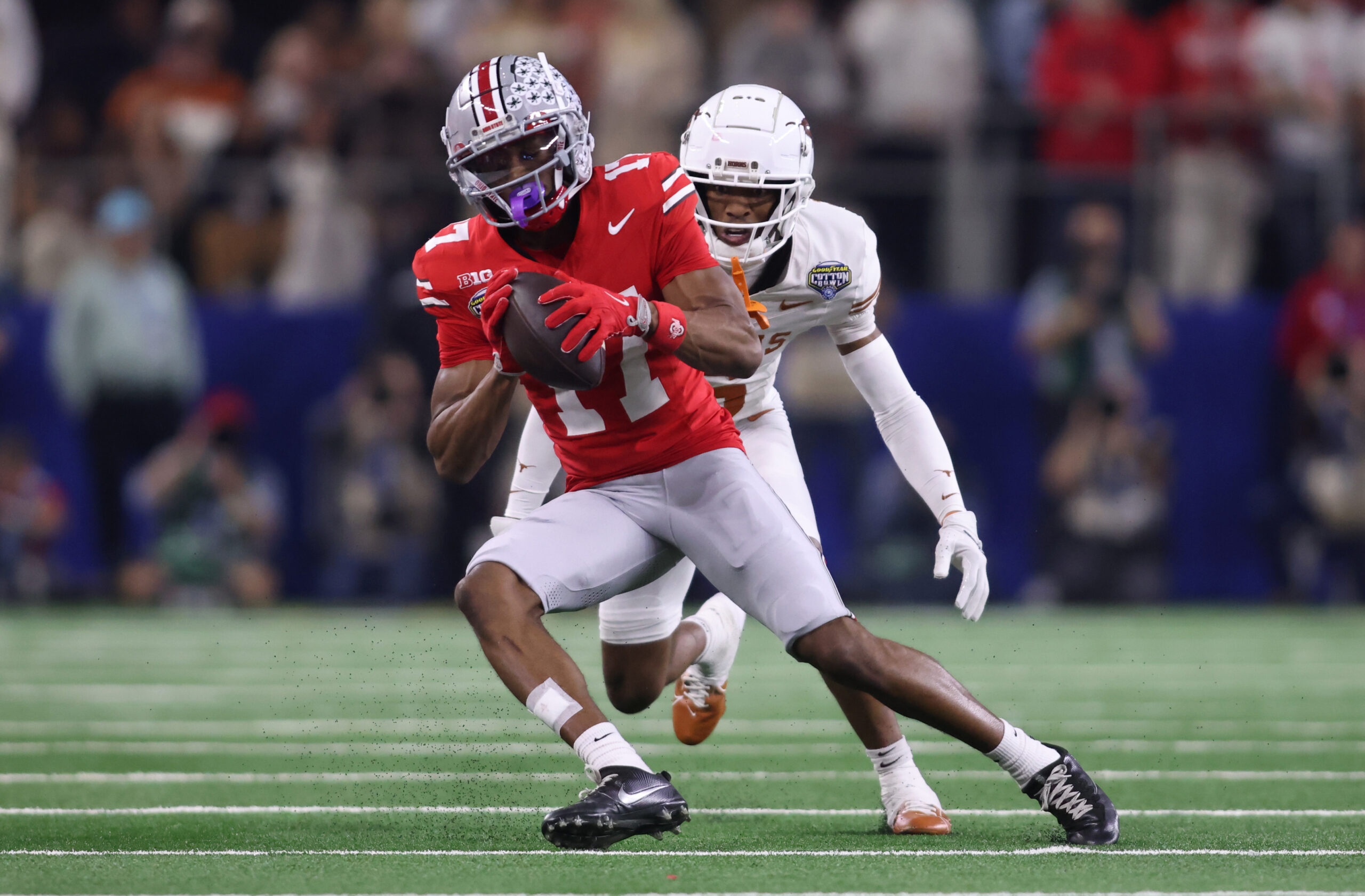 Jan 10, 2025; Arlington, Texas, USA; Ohio State Buckeyes wide receiver Carnell Tate (17) makes a catch against Texas Longhorns defensive back Malik Muhammad (5) during the second quarter of the College Football Playoff semifinal in the Cotton Bowl at AT&T Stadium. 