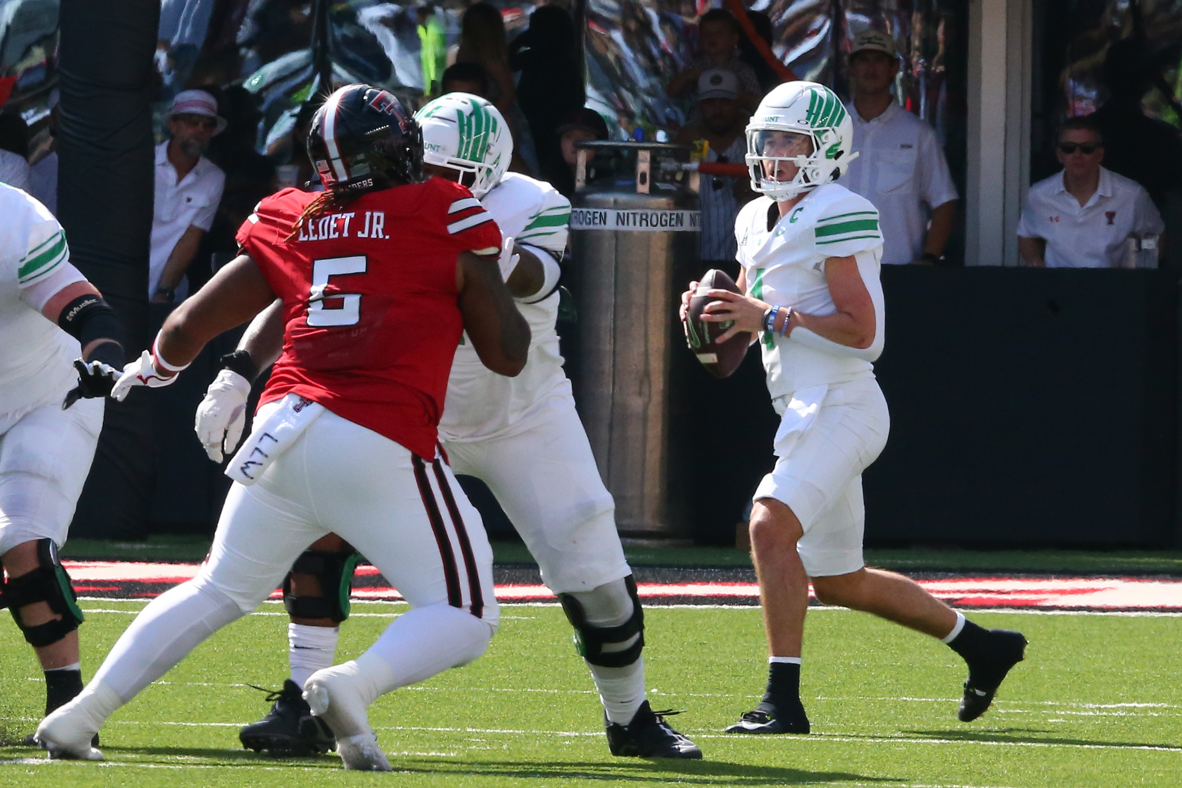 Sep 14, 2024; Lubbock, Texas, USA; North Texas Mean Green quarterback Chandler Morris (4) drops back to pass against Texas Tech Red Raiders defensive tackle Quincy Ledet Jr. (5) in the first half at Jones AT&T Stadium and Cody Campbell Field.