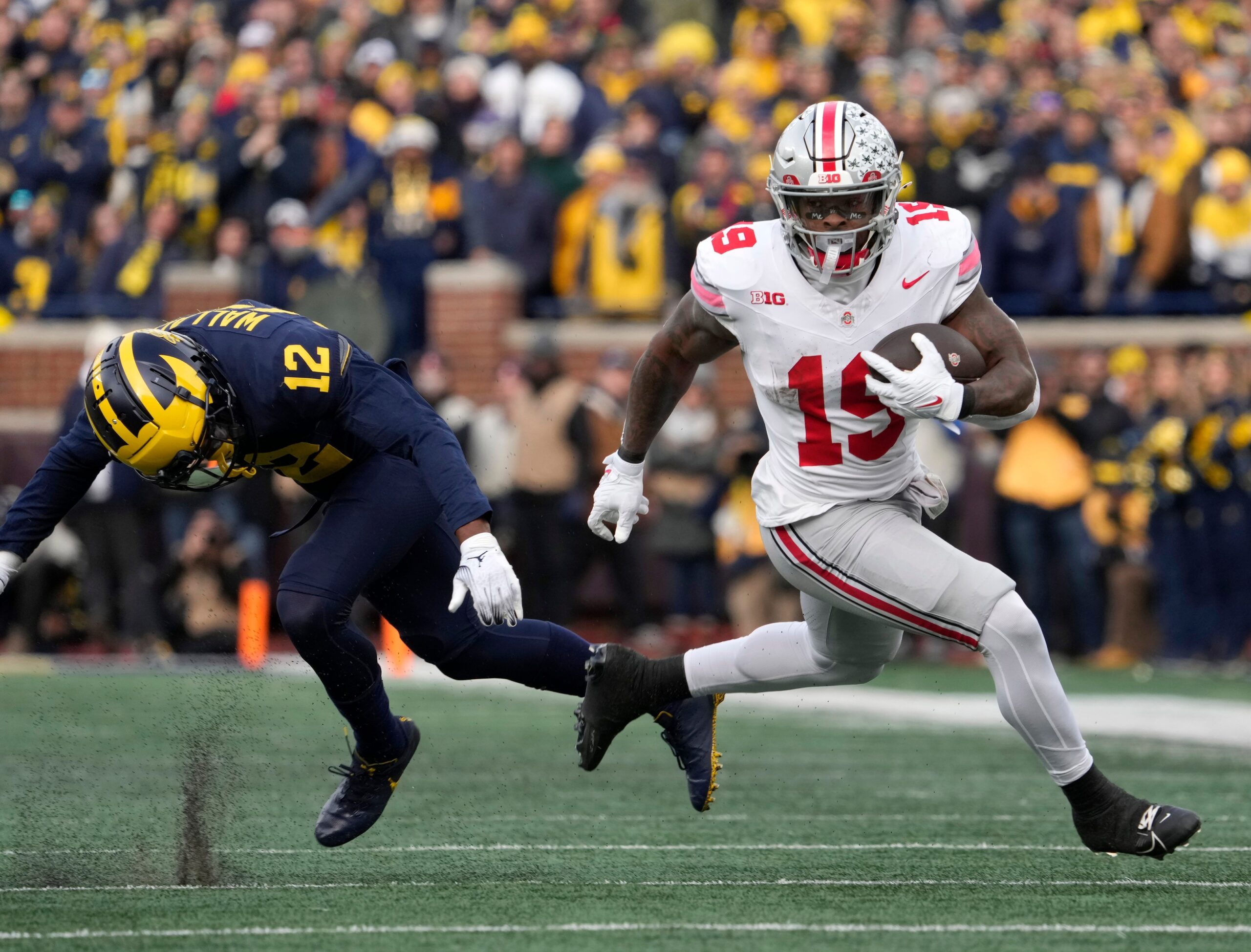 Nov. 25, 2023; Ann Arbor, Mi., USA; Ohio State Buckeyes running back Chip Trayanum (19) dodges Michigan Wolverines defensive back Josh Wallace (12) during the second half of Saturday s NCAA Division I football game at Michigan Stadium.