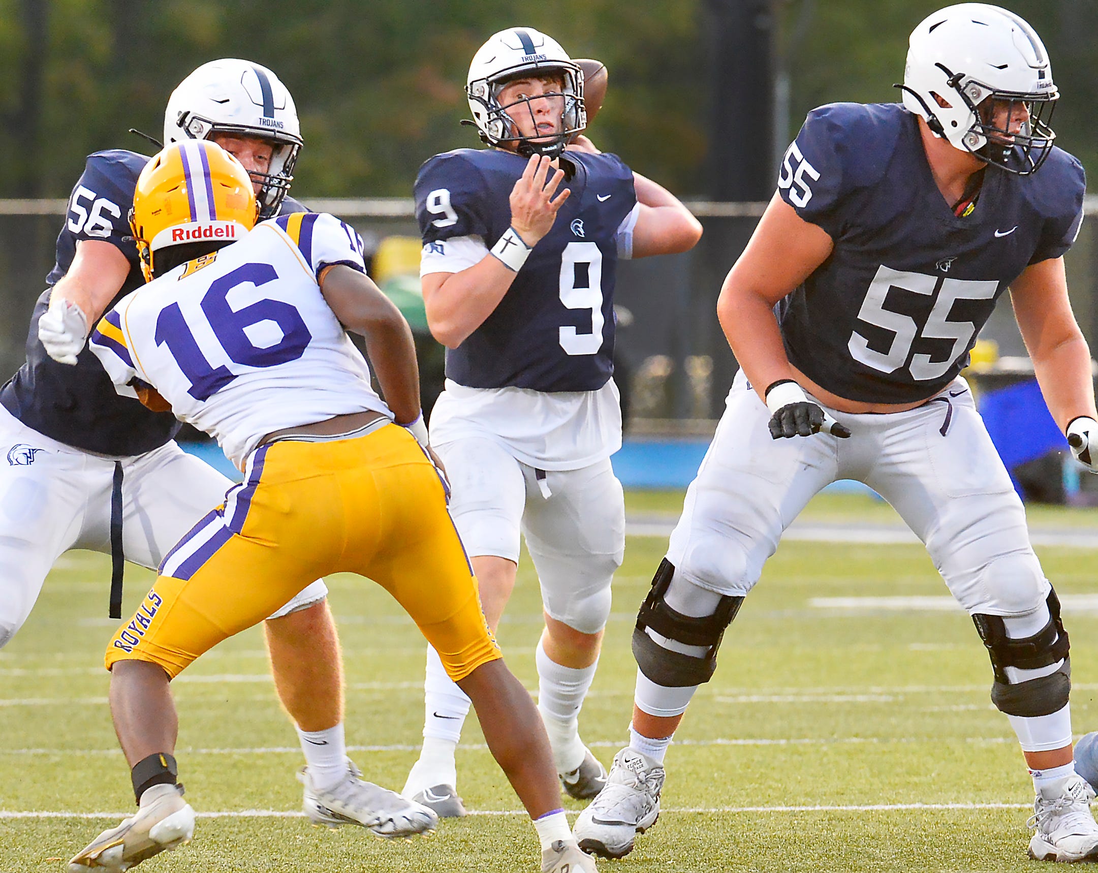 McDowell High School senior Ben Moore, center, throws against Erie High behind the blocks of senior Joey Orlando, left, and junior Cooper Cousins, right, during a District 10, Region 6 football game in Millcreek Township on Sept. 16, 2022.